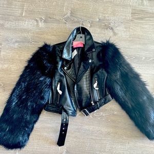 A black faux leather jacket with faux fur sleeves and zipper details